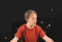 a man in a red shirt is standing with his arms outstretched in front of a purple background