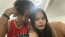 a man wearing a red chicago bulls jersey is standing next to a woman
