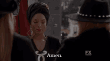 a woman wearing a turban and earrings is standing next to two other women and says amen .