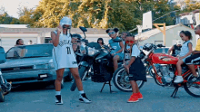 a girl wearing a jersey that says brooklyn is standing next to a group of people on motorcycles