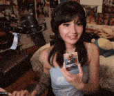 a woman wearing headphones and a tank top that says ' ucsd ' on it
