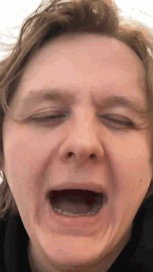 a close up of a person making a funny face with their mouth open