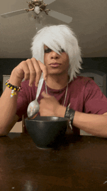 a man with white hair holds a spoon over a bowl