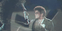 a man in a suit is playing a piano in a blurry image