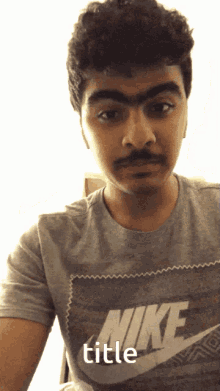 a man with a fake mustache wearing a grey nike shirt