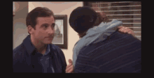 two men are hugging each other in front of a picture on the wall
