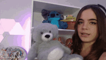 a woman holds a teddy bear in front of a sign that says ' codes '