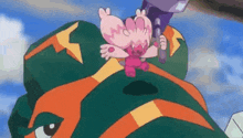 a cartoon character is sitting on top of a green and orange monster .