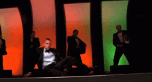 a man in a tuxedo is pointing at something