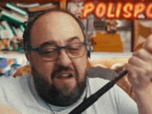 a man wearing headphones and glasses is standing in front of a sign that says polispol