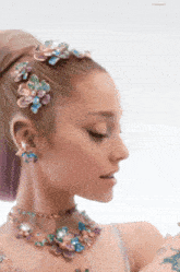 a woman wearing a necklace and a headband with flowers in her hair
