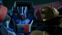 a blue robot with a red and white stripe on the chest