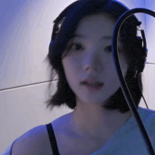a woman wearing headphones and a microphone is looking at the camera .