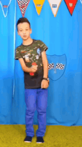 a man in a colorful shirt is standing in front of a blue wall with checkered flags