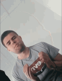 a man wearing a t-shirt that says ' iv9 ' on it holds something in his hands