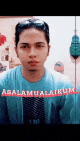 a man wearing a blue shirt that says " assalamualaikum " on it
