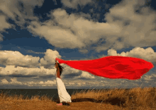 woman field red flowing clouds