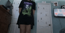 a girl wearing a dracula t-shirt in a bedroom