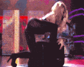 a pixelated image of a woman kneeling down on a stage