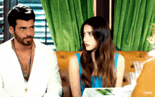 a man and a woman sitting at a table with sophie written on the bottom right