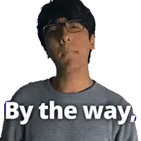 a man wearing glasses and a grey shirt with the words by the way written on it