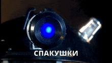 a close up of a camera lens with a blue light coming out of it and the words " spakushki " underneath