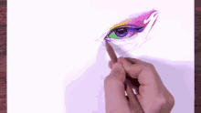 a person is drawing a woman 's eye with a yellow pencil