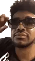 a man with a beard is wearing sunglasses and making a face .
