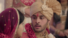 a bride and groom are standing next to each other and the groom has a red dot on his forehead