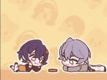 a couple of anime characters are laying on the floor eating cookies .