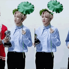 a man in a blue shirt is holding a trophy and a flower
