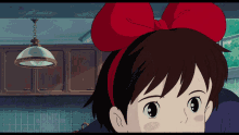 a girl with a red bow on her head looks at the camera