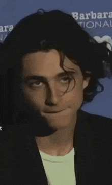 a close up of a young man making a funny face with his mouth open .