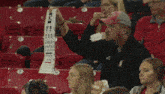 a man in a red hat is holding up a sign that says ' ucsd '
