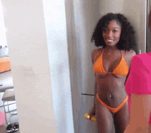 a woman in a bikini is standing in front of a mirror .
