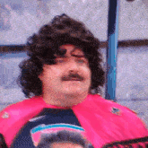 a man with a wig and mustache is wearing a pink shirt that says sharks