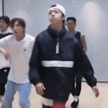 a group of young men are standing in a room and dancing .