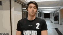 a young man wearing a black shirt with the number 2 on it .