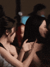 a group of women are hugging each other and one of them has a ring on her finger