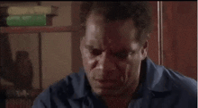 a man in a blue shirt is sitting at a table with his mouth open and saying `` the dog grabbed my ass '' .