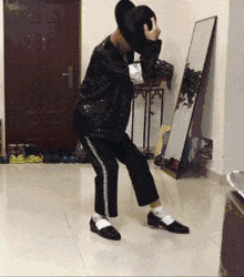 a person is dancing in front of a mirror and a door