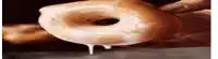 a close up of a person holding a glazed donut with icing dripping from it .