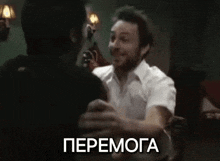 two men are hugging each other in a room with the word " peemoga " written on the bottom