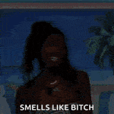 a woman is standing on a beach and says smells like bitch .