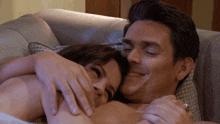 a man and woman are hugging on a couch