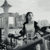 a woman in armor is standing in front of a cross