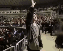 a man is standing in front of a crowd in a stadium .