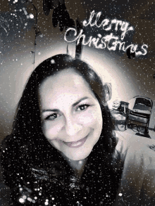 a woman is smiling in front of a merry christmas greeting