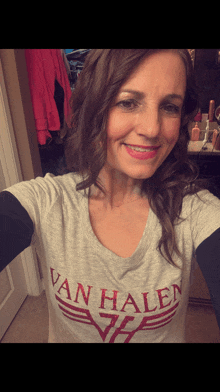 a woman wearing a van halen t-shirt smiles for the camera