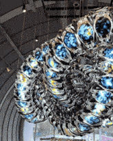 a large circular sculpture with blue and yellow circles is hanging from the ceiling